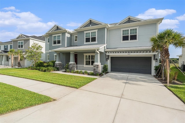 33774 Castaway Loop, Wesley Chapel, FL 33543 - view of front of home featuring covered porch, stucco siding, concrete driveway, a garage, and a front yard