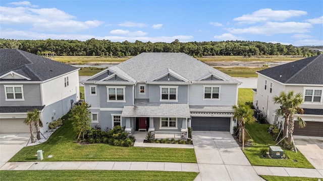 33774 Castaway Loop, Wesley Chapel, FL 33543 - view of front of house with concrete driveway, a porch, an attached garage, and a front yard