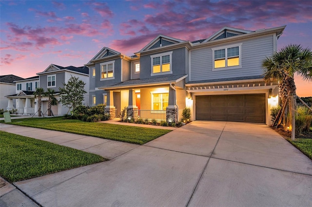 33774 Castaway Loop, Wesley Chapel, FL 33543 - view of front facade featuring covered porch, a garage, concrete driveway, stucco siding, and a front lawn