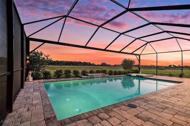 33774 Castaway Loop, Wesley Chapel, FL 33543 - pool at dusk featuring a patio area, a pool with connected hot tub, and a lanai