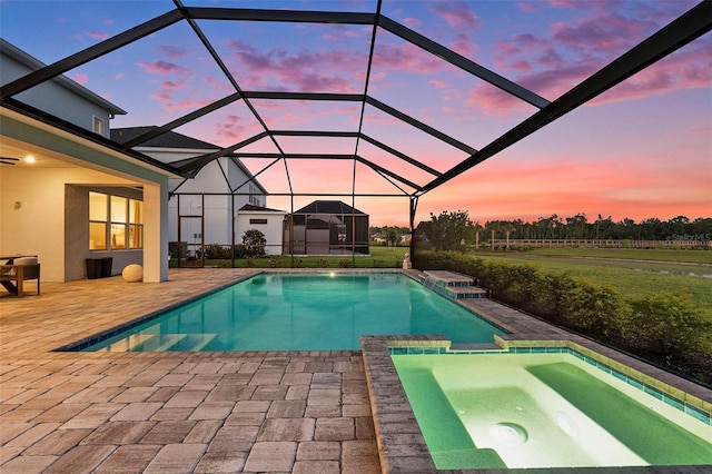 33774 Castaway Loop, Wesley Chapel, FL 33543 - pool at dusk featuring a patio, a pool with connected hot tub, and a lanai