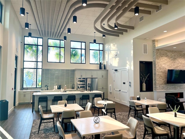 33774 Castaway Loop, Wesley Chapel, FL 33543 - dining space featuring a towering ceiling, dark wood-style flooring, and baseboards