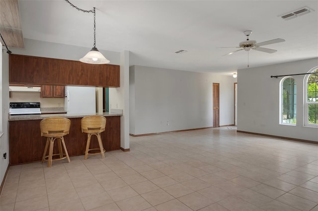8332 Berkeley Manor Blvd, Spring Hill, FL 34606 - kitchen featuring freestanding refrigerator, range, a ceiling fan, decorative light fixtures, and a kitchen bar