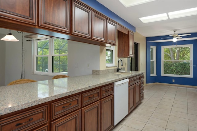 8332 Berkeley Manor Blvd, Spring Hill, FL 34606 - kitchen featuring white dishwasher, a sink, light stone counters, and light tile patterned floors