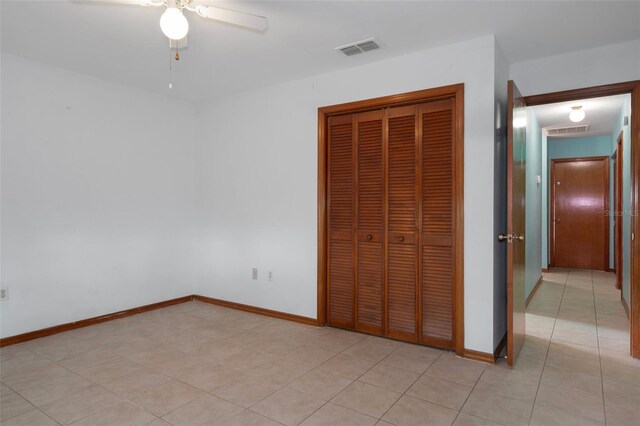 8332 Berkeley Manor Blvd, Spring Hill, FL 34606 - unfurnished bedroom with a closet, baseboards, ceiling fan, and light tile patterned floors