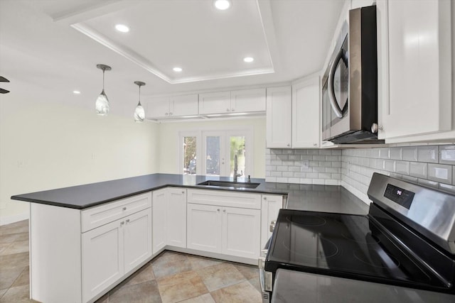 13926 Darlene Ave, Hudson, FL 34667 - kitchen featuring stainless steel appliances, a sink, dark countertops, a raised ceiling, and decorative backsplash