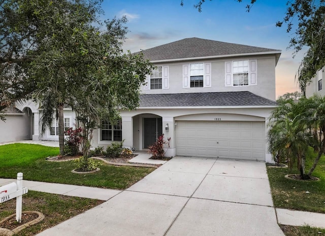 1933 Fruitridge St, Brandon, FL 33510 - traditional home featuring a garage, stucco siding, a front lawn, and a shingled roof