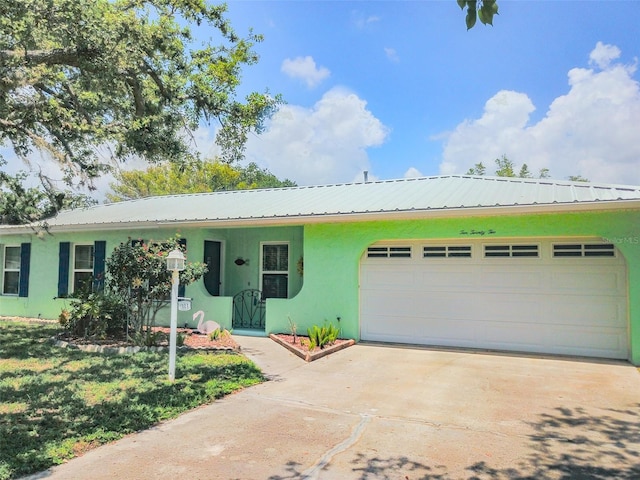 1022 Greenbriar Dr, Brandon, FL 33511 - view of front of house featuring an attached garage, stucco siding, driveway, and metal roof