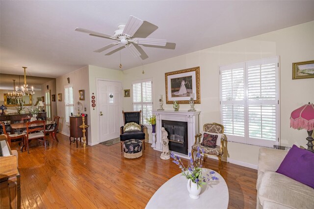 1022 Greenbriar Dr, Brandon, FL 33511 - living area with a glass covered fireplace, baseboards, wood finished floors, ceiling fan, and a chandelier