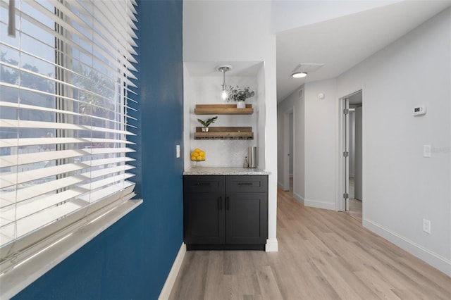500 New York Ave Unit 23, Dunedin, FL 34698 - indoor dry bar with light wood-style floors, baseboards, and tasteful backsplash