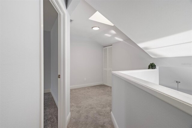 500 New York Ave Unit 23, Dunedin, FL 34698 - hall featuring light carpet, lofted ceiling, and baseboards