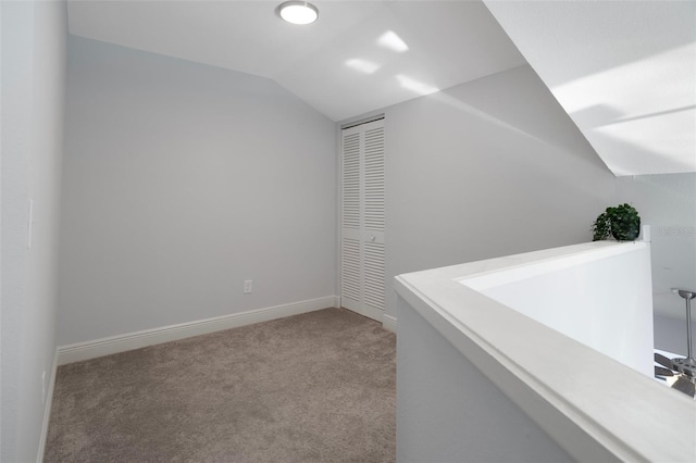 500 New York Ave Unit 23, Dunedin, FL 34698 - hallway with vaulted ceiling, carpet floors, and baseboards
