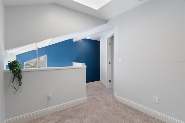 500 New York Ave Unit 23, Dunedin, FL 34698 - unfurnished room with vaulted ceiling, carpet flooring, a skylight, and baseboards