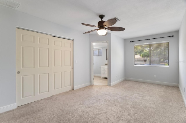 500 New York Ave Unit 23, Dunedin, FL 34698 - unfurnished bedroom with light colored carpet, a closet, ensuite bath, baseboards, and ceiling fan