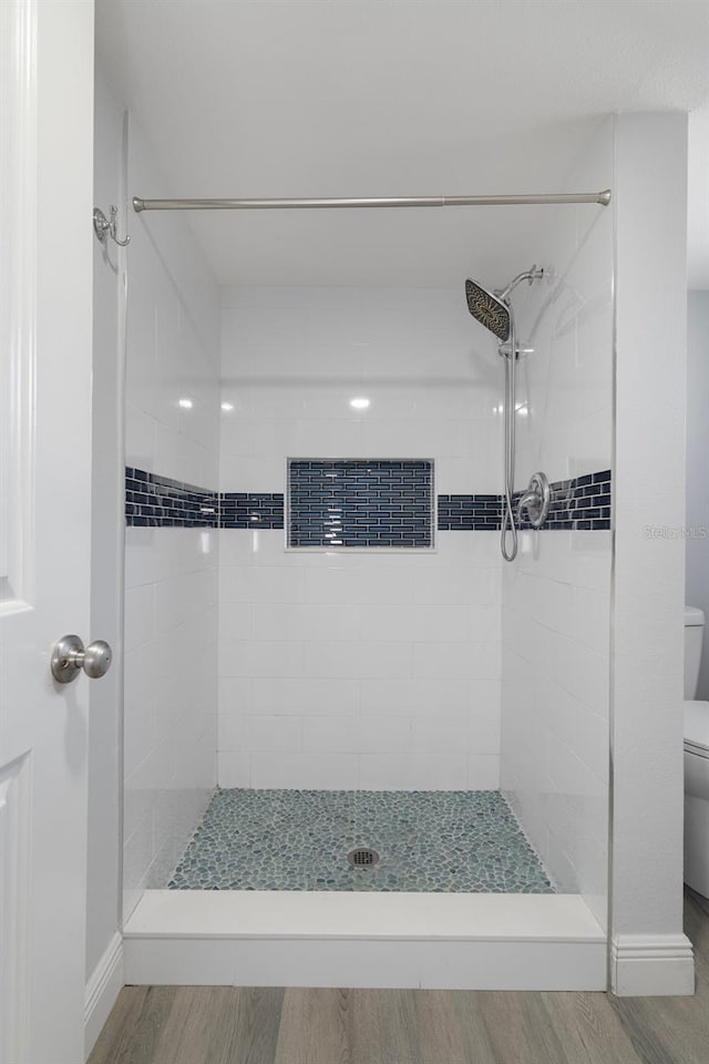 500 New York Ave Unit 23, Dunedin, FL 34698 - bathroom with toilet, a shower stall, wood finished floors, and baseboards