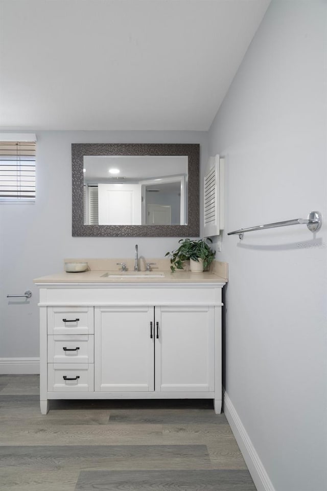 500 New York Ave Unit 23, Dunedin, FL 34698 - bathroom with vanity, wood finished floors, and baseboards