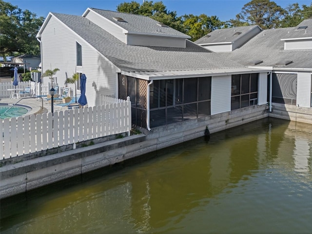500 New York Ave Unit 23, Dunedin, FL 34698 - back of house with a sunroom, a patio area, a shingled roof, and a water view