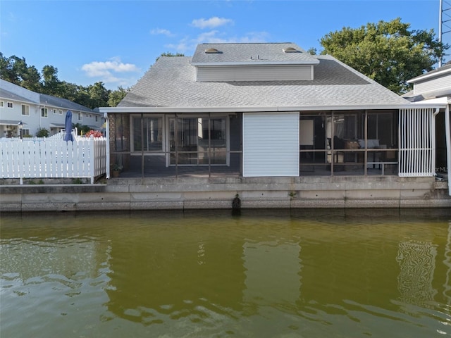 500 New York Ave Unit 23, Dunedin, FL 34698 - back of property featuring a sunroom, roof with shingles, and a water view