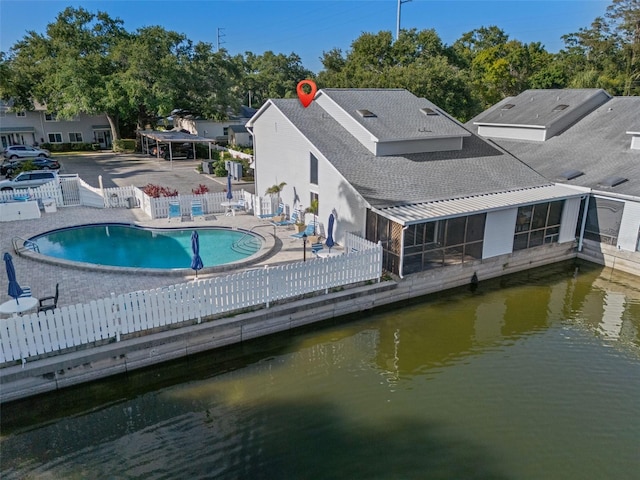 500 New York Ave Unit 23, Dunedin, FL 34698 - rear view of house featuring a patio area, a community pool, a shingled roof, and a water view