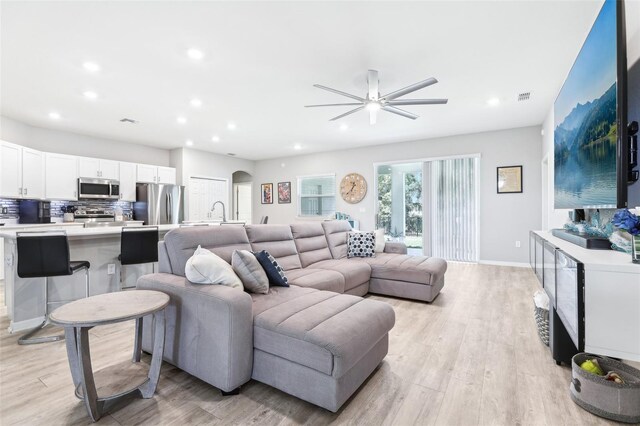 229 St Thomas Dr, Mulberry, FL 33860 - living room featuring ceiling fan, recessed lighting, light wood-style flooring, arched walkways, and baseboards