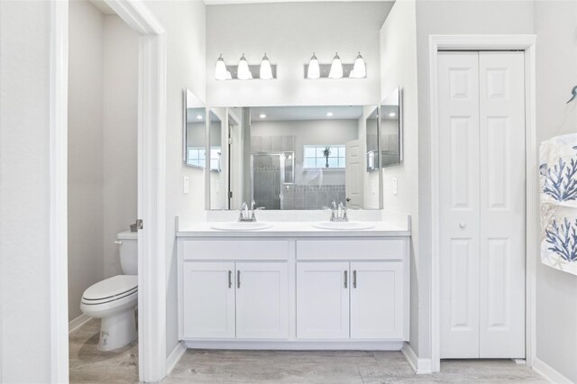 229 St Thomas Dr, Mulberry, FL 33860 - bathroom with a closet, toilet, a stall shower, double vanity, and wood finished floors