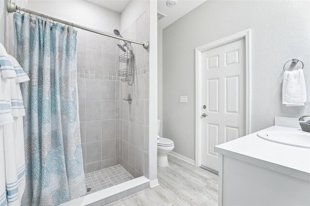 229 St Thomas Dr, Mulberry, FL 33860 - bathroom with a tile shower, toilet, wood finished floors, and vanity