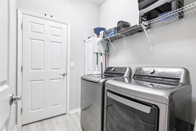 229 St Thomas Dr, Mulberry, FL 33860 - washroom with washing machine and clothes dryer and light wood finished floors