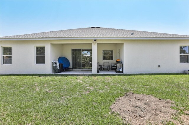 229 St Thomas Dr, Mulberry, FL 33860 - back of property featuring a patio, stucco siding, a lawn, and a shingled roof