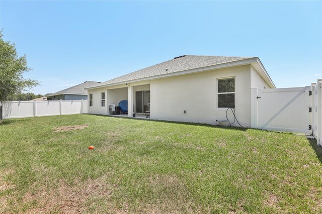229 St Thomas Dr, Mulberry, FL 33860 - rear view of property featuring a gate, stucco siding, and roof with shingles