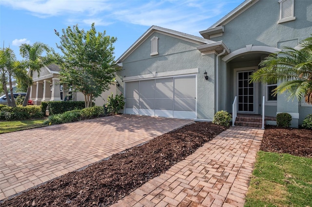 212 Shell Creek Ct, Apollo Beach, FL 33572 - view of front facade featuring stucco siding, decorative driveway, and a garage