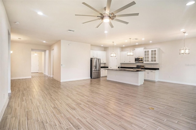 212 Shell Creek Ct, Apollo Beach, FL 33572 - kitchen featuring appliances with stainless steel finishes, open floor plan, dark countertops, a sink, and recessed lighting