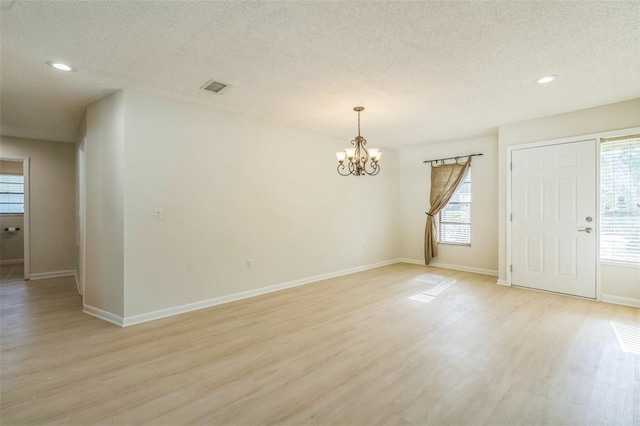2204 78th St W, Bradenton, FL 34209 - unfurnished room with light wood-type flooring, a textured ceiling, a chandelier, baseboards, and recessed lighting