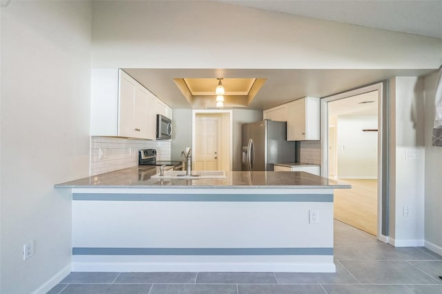 2204 78th St W, Bradenton, FL 34209 - kitchen with stainless steel appliances, a raised ceiling, a sink, and decorative backsplash