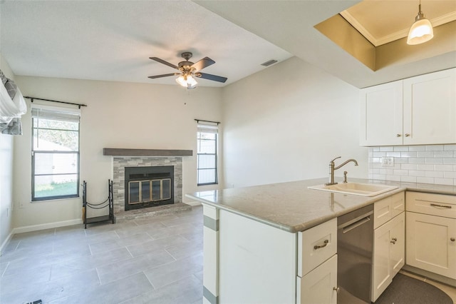 2204 78th St W, Bradenton, FL 34209 - kitchen with stainless steel dishwasher, a sink, a ceiling fan, a glass covered fireplace, and plenty of natural light