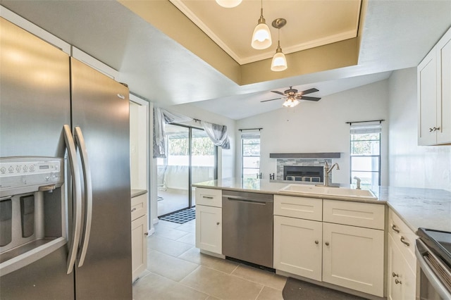 2204 78th St W, Bradenton, FL 34209 - kitchen with appliances with stainless steel finishes, a sink, a fireplace, white cabinets, and light tile patterned floors