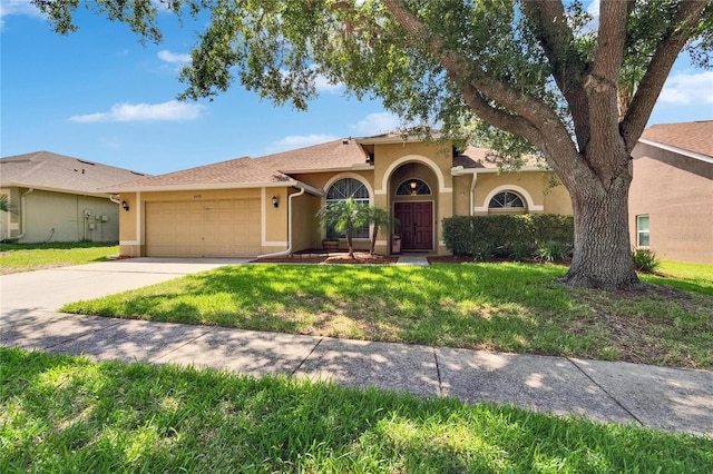 4418 River Overlook Dr, Valrico, FL 33596 - mediterranean / spanish home with stucco siding, an attached garage, a front lawn, and driveway