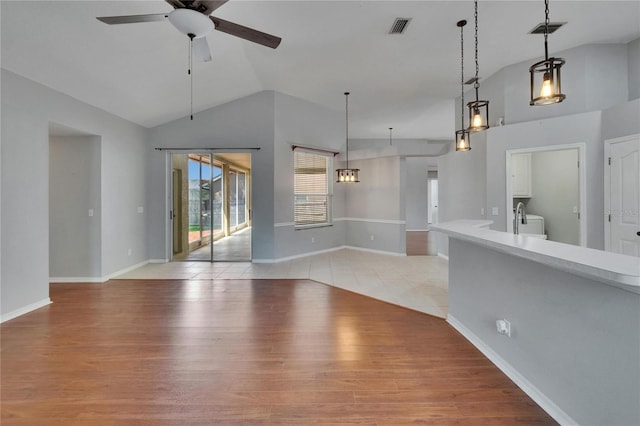 4418 River Overlook Dr, Valrico, FL 33596 - unfurnished living room featuring ceiling fan, vaulted ceiling, light wood-style flooring, washer / clothes dryer, and baseboards