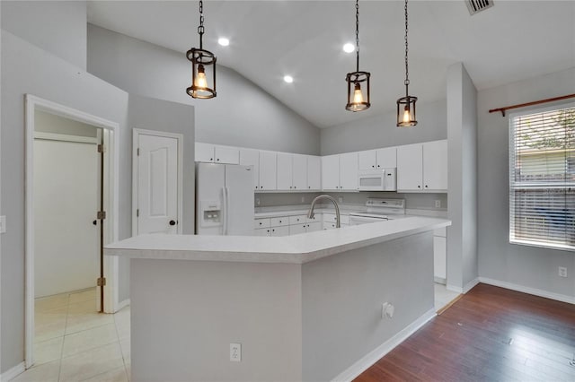 4418 River Overlook Dr, Valrico, FL 33596 - kitchen with white appliances, light countertops, white cabinetry, and high vaulted ceiling