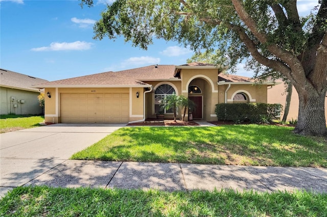 4418 River Overlook Dr, Valrico, FL 33596 - mediterranean / spanish home featuring stucco siding, a garage, concrete driveway, and a front lawn