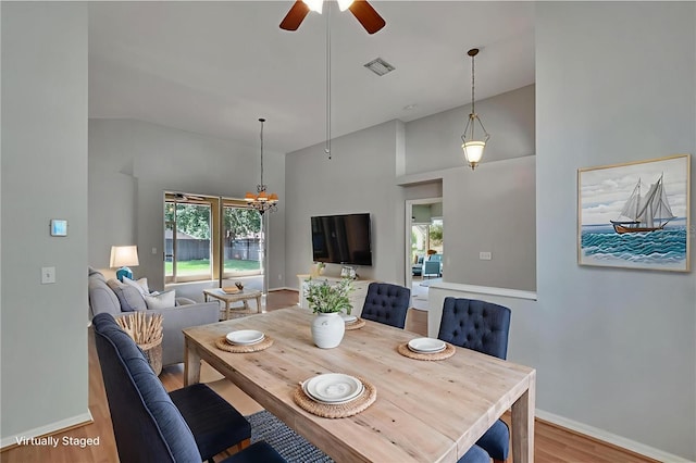4418 River Overlook Dr, Valrico, FL 33596 - dining space featuring wood finished floors, ceiling fan, high vaulted ceiling, and a chandelier