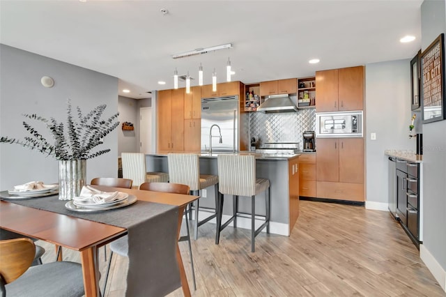 1120 E Kennedy Blvd Unit 1512, Tampa, FL 33602 - kitchen featuring built in appliances, under cabinet range hood, recessed lighting, light wood-type flooring, and backsplash
