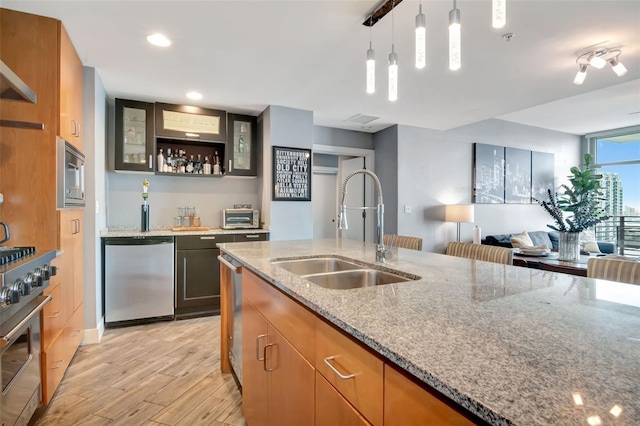 1120 E Kennedy Blvd Unit 1512, Tampa, FL 33602 - kitchen featuring a sink, appliances with stainless steel finishes, light wood-style floors, light stone counters, and glass insert cabinets