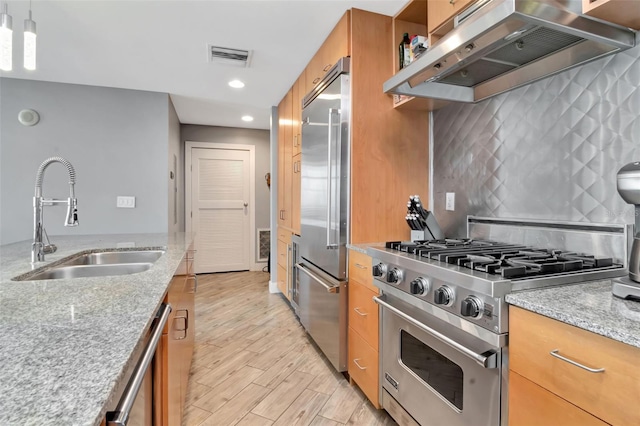 1120 E Kennedy Blvd Unit 1512, Tampa, FL 33602 - kitchen featuring high quality appliances, a sink, under cabinet range hood, brown cabinets, and recessed lighting
