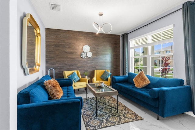 30936 Summer Sun Loop, Wesley Chapel, FL 33545 - living room featuring an accent wall, wood walls, and marble look tiles