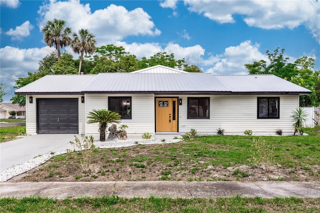1161 Orangewood Ave, Deland, FL 32724 - view of front of property featuring a garage, concrete driveway, and metal roof