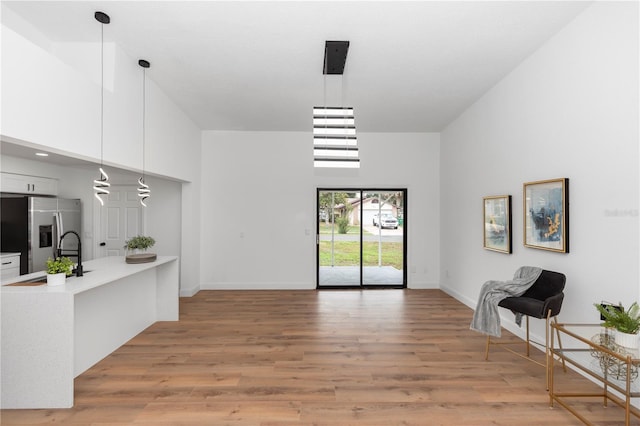 1161 Orangewood Ave, Deland, FL 32724 - living area featuring a high ceiling, light wood-type flooring, and baseboards