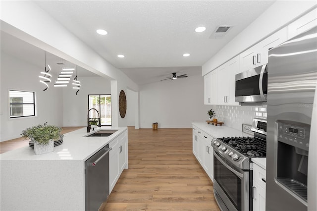 1161 Orangewood Ave, Deland, FL 32724 - kitchen with appliances with stainless steel finishes, a sink, recessed lighting, light wood-style flooring, and tasteful backsplash