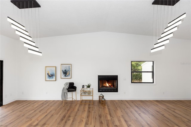 1161 Orangewood Ave, Deland, FL 32724 - living area with a warm lit fireplace, wood finished floors, high vaulted ceiling, and baseboards