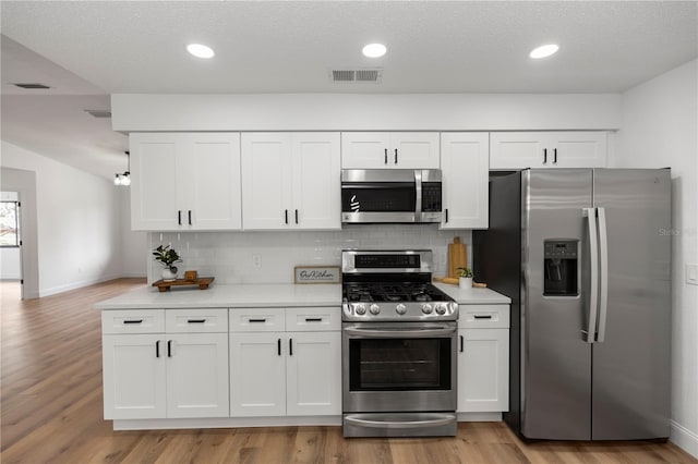 1161 Orangewood Ave, Deland, FL 32724 - kitchen featuring appliances with stainless steel finishes, light countertops, white cabinetry, backsplash, and recessed lighting