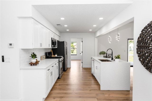 1161 Orangewood Ave, Deland, FL 32724 - kitchen featuring stainless steel appliances, a sink, recessed lighting, white cabinets, and light wood-style flooring